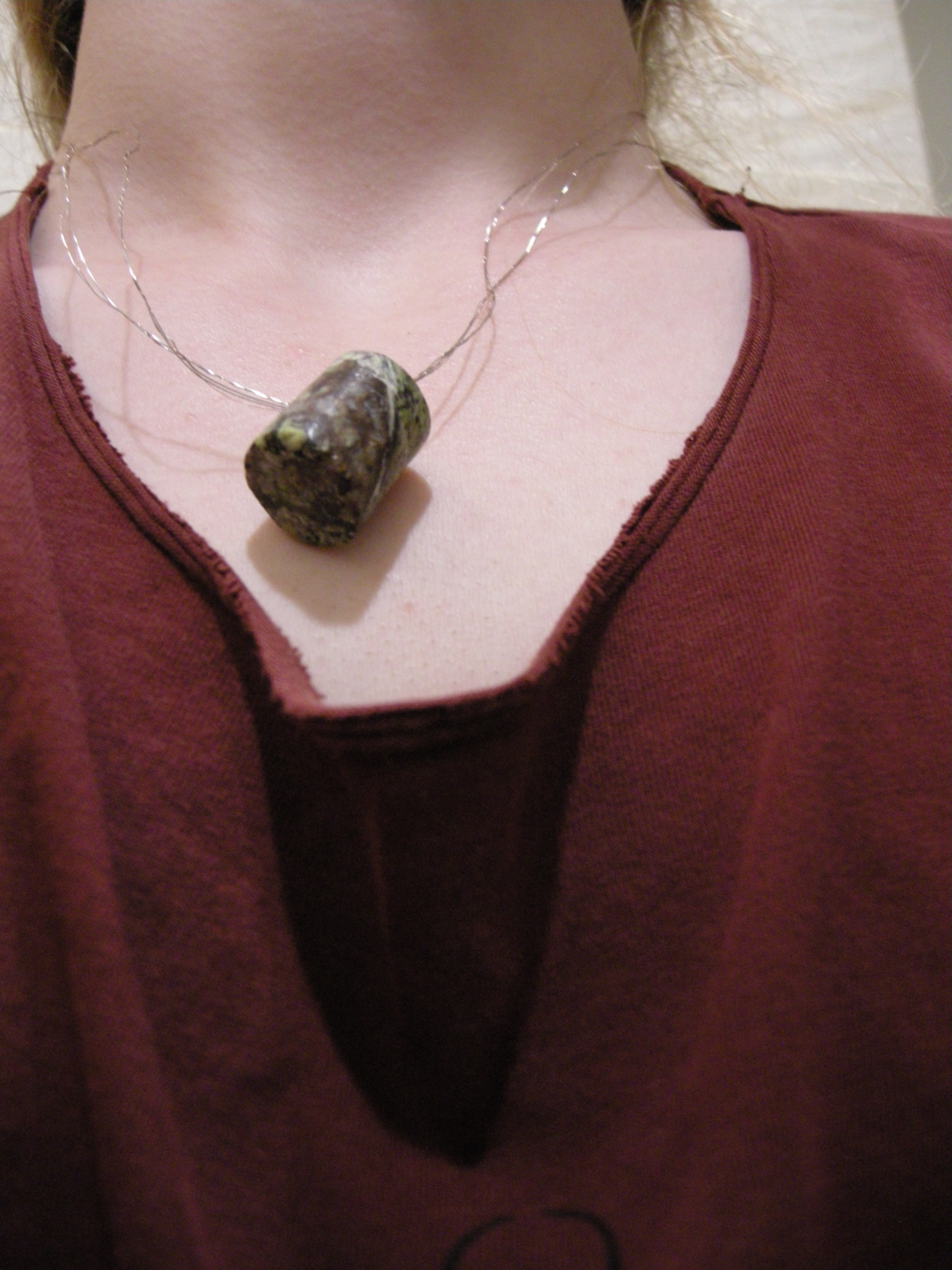 Aforementioned cylinder and wire braid hanging from a neck.