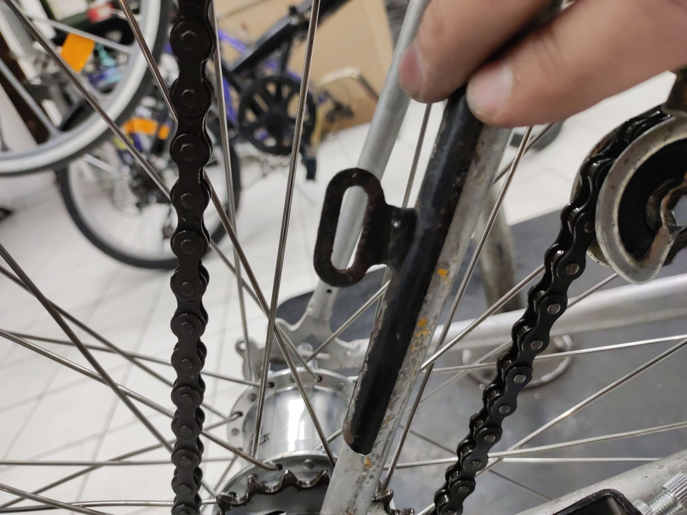 a piece of metal held by hand to the seat stay of the tallbike